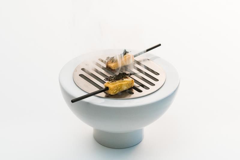 豆腐串摆放在小型炭炉上。