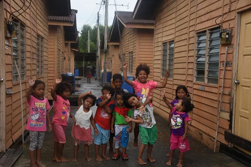 吉胆岛上居住着12户原住民，原住民小孩在屋外玩乐，新居为政府所建。