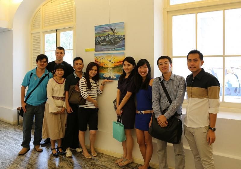 薛奇峰（前排左三）的首个画展2013年在旧国会大厦艺术之家举行，他太太陈丽丽（左二）及来自各地的友人到场给予支持。（受访者提供）