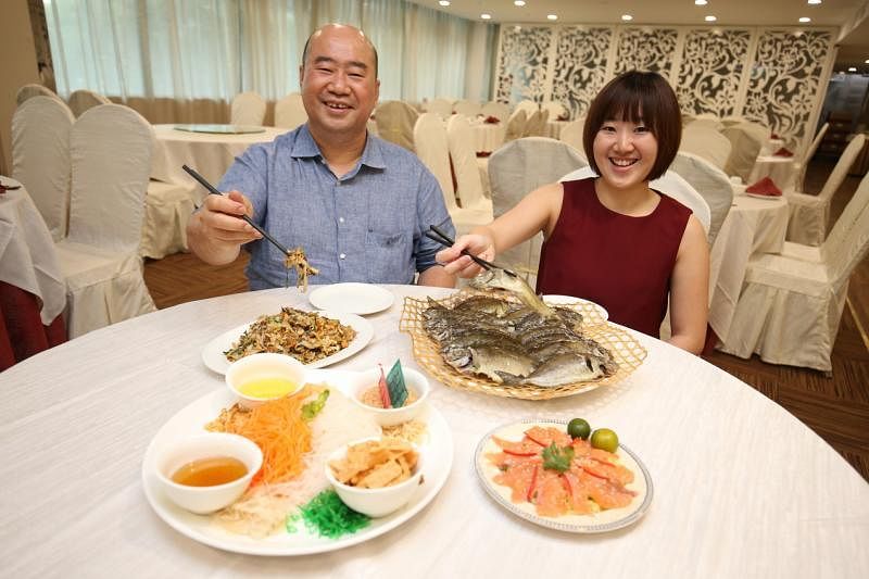 李长豪和李愿静父女过年一定吃白肚鱼、炒粿条、鱼生，一起捞起。（何家俊摄影）