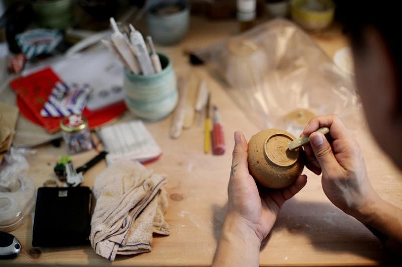 金怀奇为每个手作陶土茶具盖上“奇”印章。