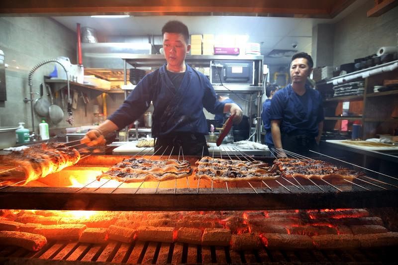 到鳗鱼餐馆Uya四代目菊川，可见师傅现场烤制鳗鱼。