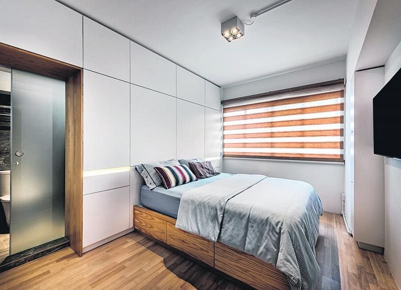 卧房从地板到床架都以木质为主，浴室入口有个门框设计，也以同样的北欧风格木料打造。