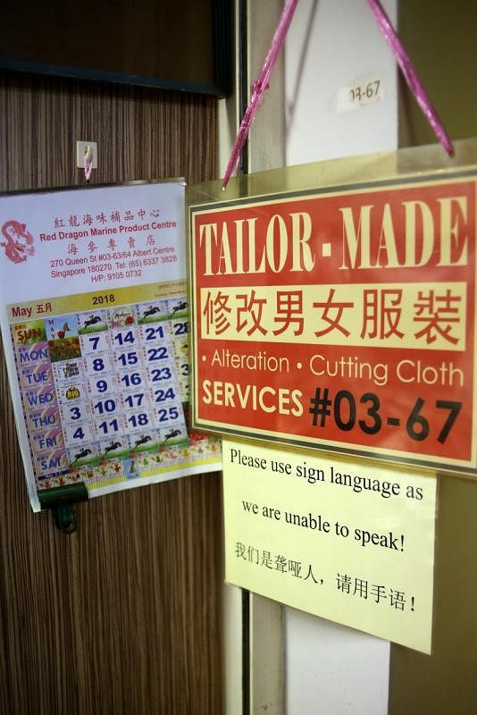 店外告示提醒人们这是聋哑人经营的裁缝店。