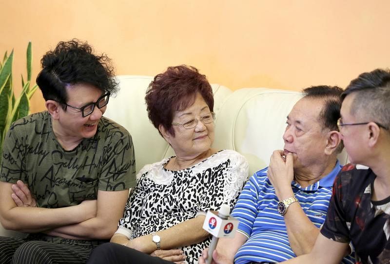 李伟菘（左）、李偲菘和妈妈听爸爸述说当年。
