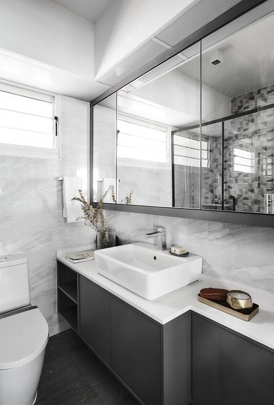 黑白色的卫浴间，以拼贴式瓷砖作为装饰墙。