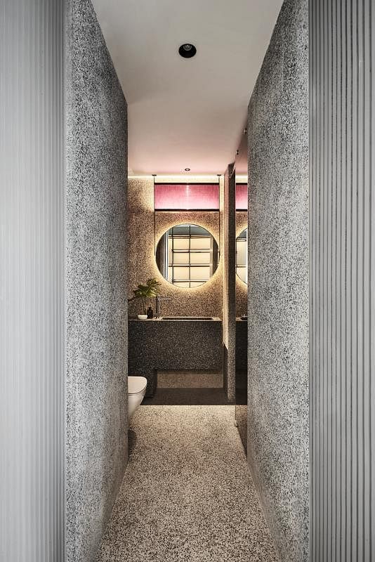 为客人打造的卫浴间讲究材料和设计，镜子上方的粉红灯箱为这空间染上绮丽的色彩。