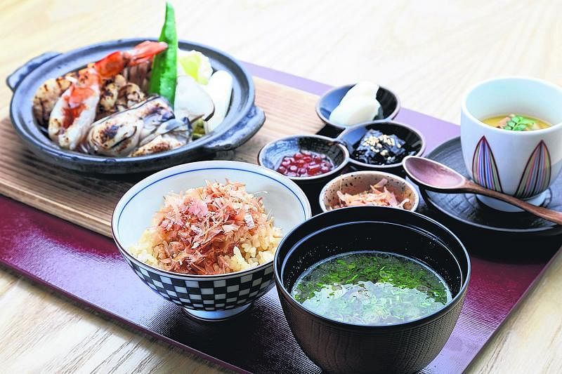 陶板烧的海鲜套餐有肉质扎实的虾子、扇贝与鲜蚝，以酱油、清酒、味醂和柚子酱调味。