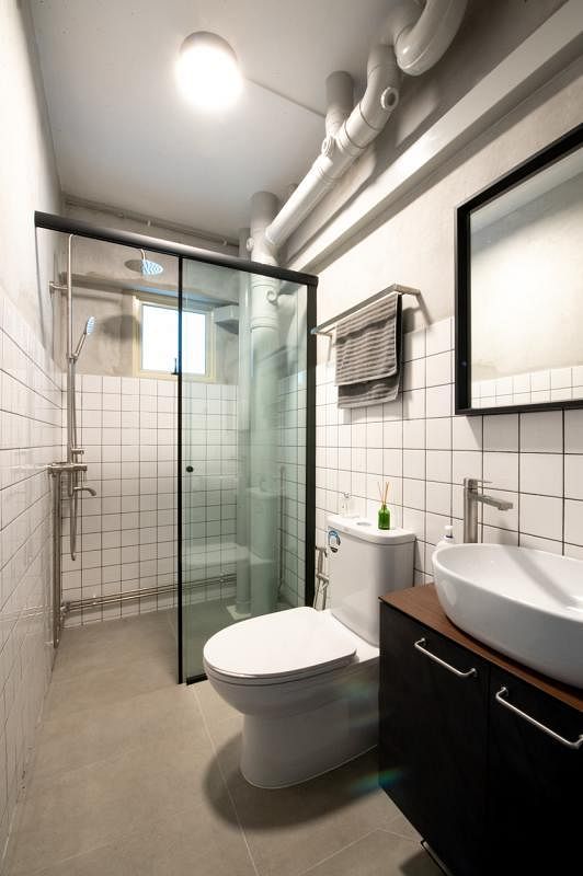 浴室内采用玻璃门将洗澡间与其他部分分隔开来，墙壁铺了白色方块砖瓦，打造出略带复古感觉的时尚感。