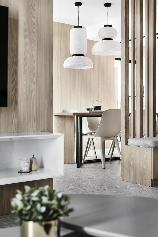 设计师巧用长木条打造相隔客厅和饭厅的“透视墙”，从厨房、饭厅也能望见客厅的动静。