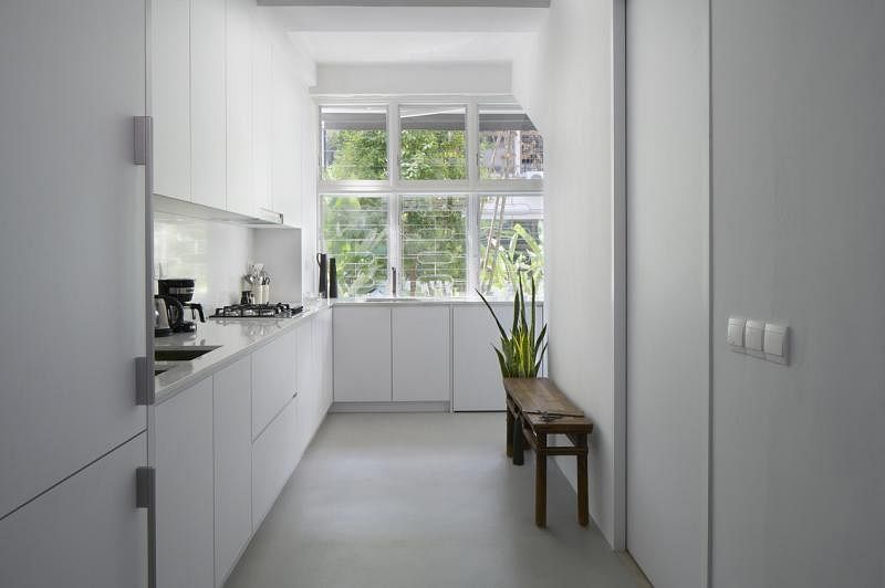 自然光透过玻璃百叶窗照进白色的厨房，窗明几净。