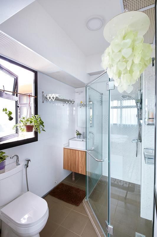设计师封上一扇门，才能在狭小的卫浴室内置入盥洗台和玻璃浴室，隔出干湿两用的功能。