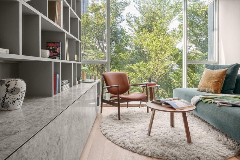 银灰色的书架、岩石纹路的橱柜中和木地板，打造一个柔和又和谐的生活空间。
