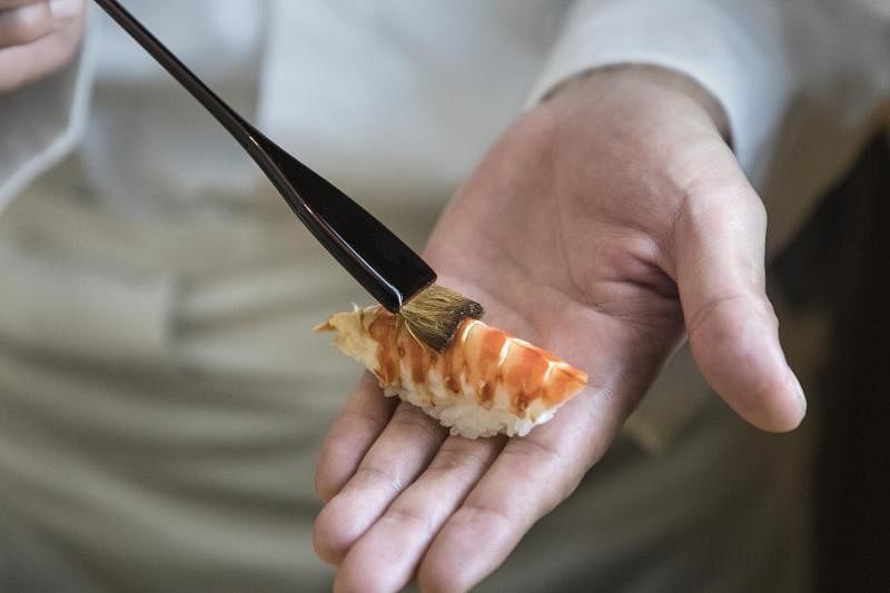 香软的寿司醋饭上，鲜嫩的车海老在特制酱油点缀下散发诱人色泽。