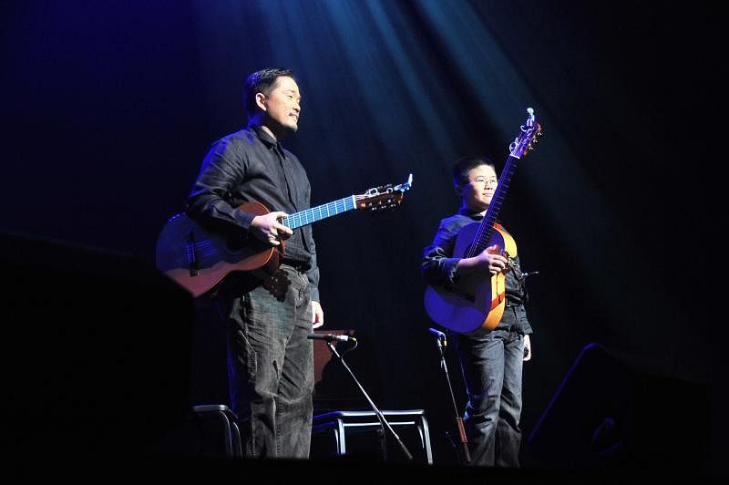 娄宝宏（左）和娄楷文父子在2009年儿童慈善音乐会上演出。（受访者提供）