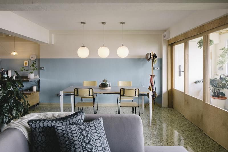 设计师为饭厅选用水蓝油漆完美地接连上厨房的旧墙瓷砖，制造出延绵深长的空间感，就连三盏圆吊灯的长度也计算得恰好，刚好停在水蓝与白漆的界线上。