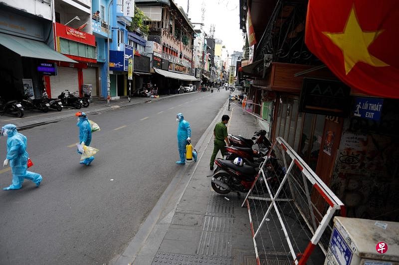 越南冠病疫情重灾区胡志明市周五起封锁15天，所有非必要领域经济活动一律暂停。图为胡志明市街头冷冷清清，只有医护人员忙着到各处为民众进行冠病检测。（法新社）