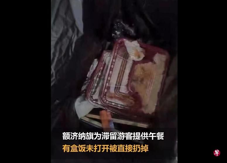 有滞留内蒙古的游客被发现，将政府每天提供的免费午餐直接扔掉。（“搜狐千里眼”微博视频截图）
