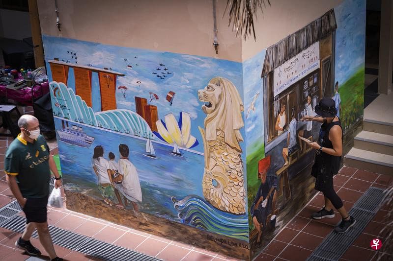 牛车水社区配合国庆而制作的壁画，包括这幅由萧宝珠（右）完成的作品，交织着新加坡昔日与现在的风貌。（陈来福摄）
