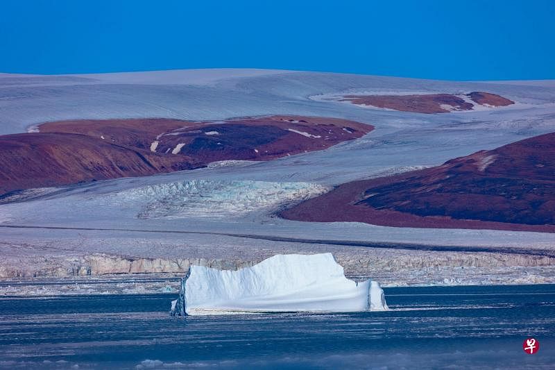 气候暖化使格陵兰岛冰山加速融化。7月18日，格陵兰岛北部巴芬湾（Baffin Bay）靠近皮图菲克（Pituffik）的水域出现一座漂浮的冰山。（法新社）