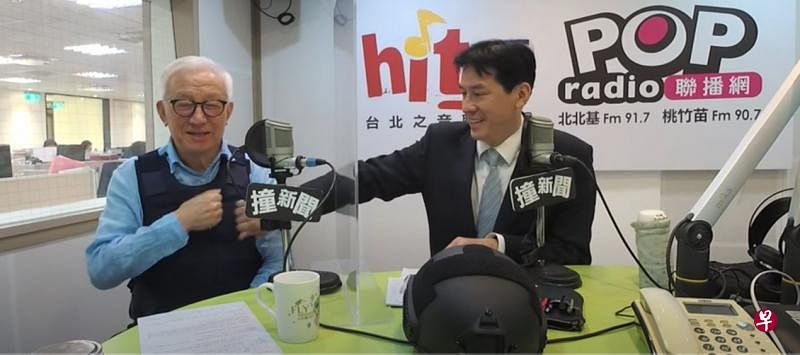 台湾联华电子创办人曹兴诚穿着防弹背心上著名媒体人黄暐瀚的广播节目。桌上还有一副防弹钢盔。（视频截图）