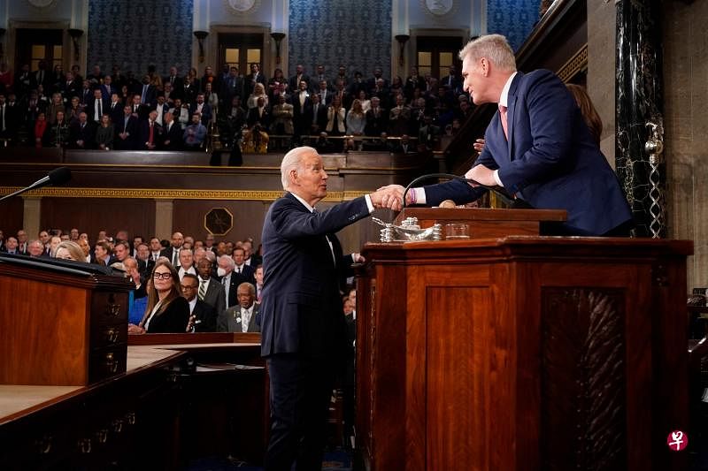 拜登（左）在发表国情咨文演讲前，与共和党籍的众议院议长麦卡锡握手。（法新社）