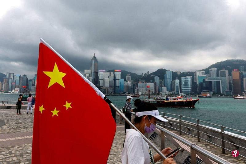 美国国务院发表报告，批评北京在香港实施的《香港国安法》持续侵蚀香港法院的独立性和法治。图为一名支持者在香港回归24周年之际手举中国国旗。（路透社档案图片）
