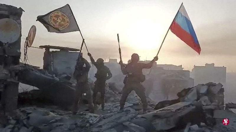 5月20日，俄罗斯瓦格纳雇佣军在巴赫穆特某处挥舞俄罗斯国旗和瓦格纳旗帜，庆祝该国“完全夺得”巴赫穆特。（路透社）