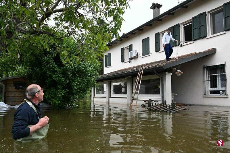 5月20日，意大利北部艾米利亚—罗马涅区的拉文纳（Ravenna）市多处房屋被洪水淹没，图为当地居民试图解救一名受困男子。（法新社）