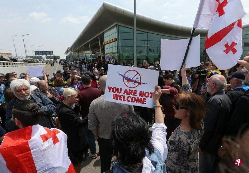 一架俄罗斯客机5月19日降落在第比利斯时，许多格鲁吉亚人在机场外举牌抗议，字牌上写的是“你们不受欢迎”。（路透社）