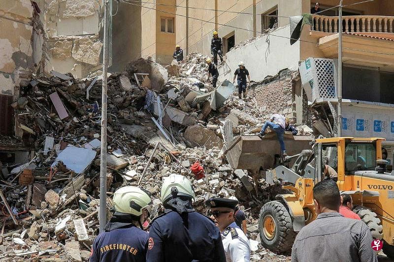 埃及亚历山大市一座13层居民楼坍塌，已造成10人丧生，另有五人失联。图为救援人员在废墟中进行搜救。（法新社）