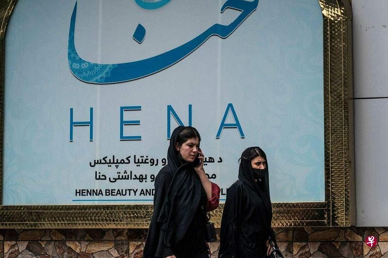 阿富汗塔利班当局下令全国各地的美容院在一个月内关闭。图为阿富汗妇女7月4日经过喀布尔一家美容院。（法新社）