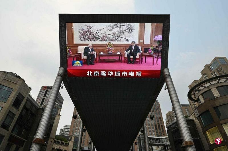 北京一商场外的大型屏幕，显示基辛格和习近平20日在北京钓鱼台国宾馆会谈。（法新社）
