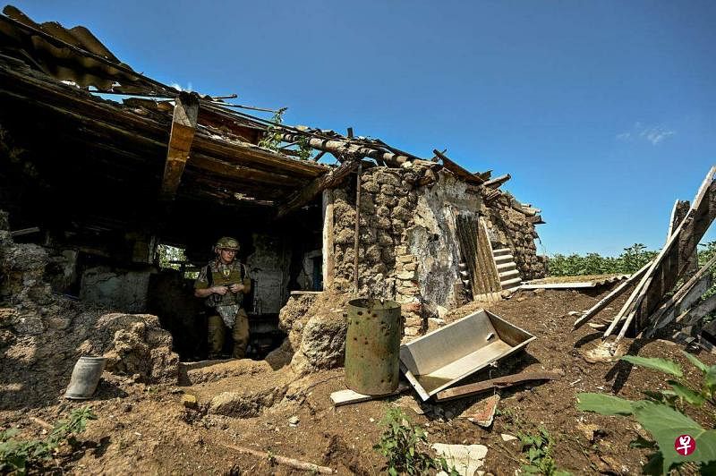 7月21日，在乌克兰东南部扎波罗热，一名乌克兰军人在最近解放的新达里夫卡村检查俄军此前待过的阵地。（路透社）