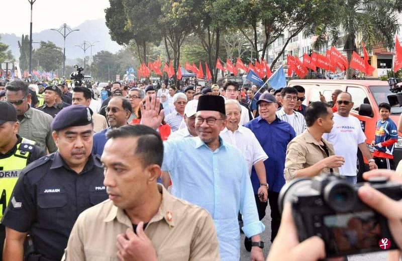 马来西亚首相安华（中）星期六（7月29日）在雪兰莪州鹅唛，与团结政府候选人和支持者一同走向提名中心迈进。（截图自星洲网）