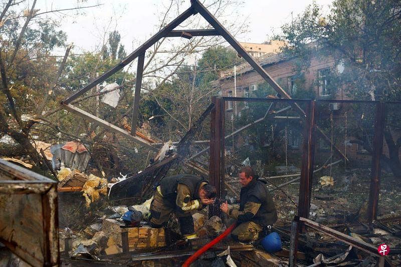 9月21日，在乌克兰基辅，消防队员在一个被俄罗斯导弹击中的住宅区进行灭火和检查工作。（路透社）