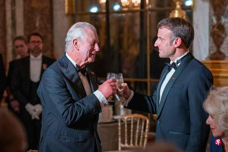 法国总统马克龙（右）9月20日在凡尔赛宫设宴款待到访的英国国王查尔斯三世。（法新社）