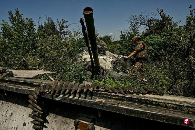虽然反攻进展比预期缓慢，但乌军近几周的报告称在扎波罗热地区取得了战略性的进展。图为7月21日，在乌克兰南部扎波罗热州，一名乌克兰士兵查看被摧毁的俄罗斯战车。（路透社）