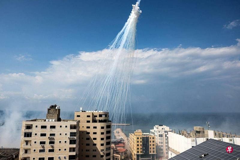 10月11日，加沙城海港上空出现由以色列燃烧弹轰炸产生的白色烟雾。（法新社）