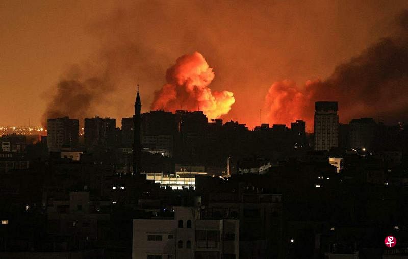 以军10月12日夜里再向加沙地带进行空袭，建筑物上空冒起浓烟。（法新社）
