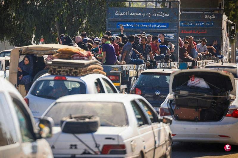 10月13日，成千上万巴勒斯坦人赶在以军压境前逃往加沙南部，路上车辆挤得水泄不通。（法新社）