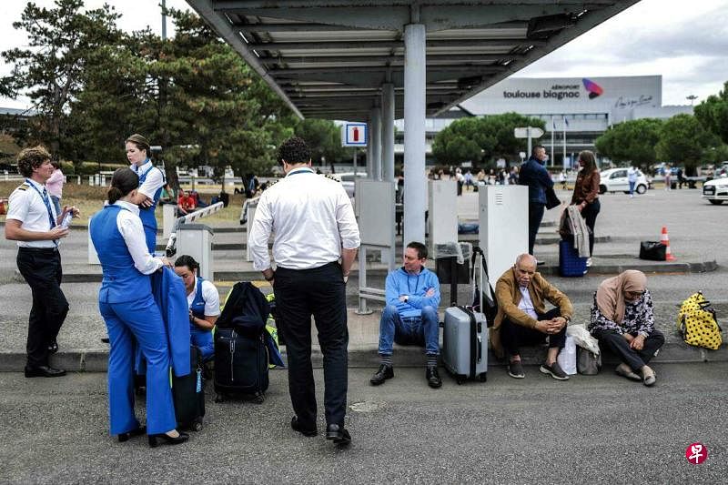 法国西南部布拉尼亚克的图卢兹-布拉尼亚克机场疏散人群后，乘客和航空公司工作人员在机场外等候。 （法新社）