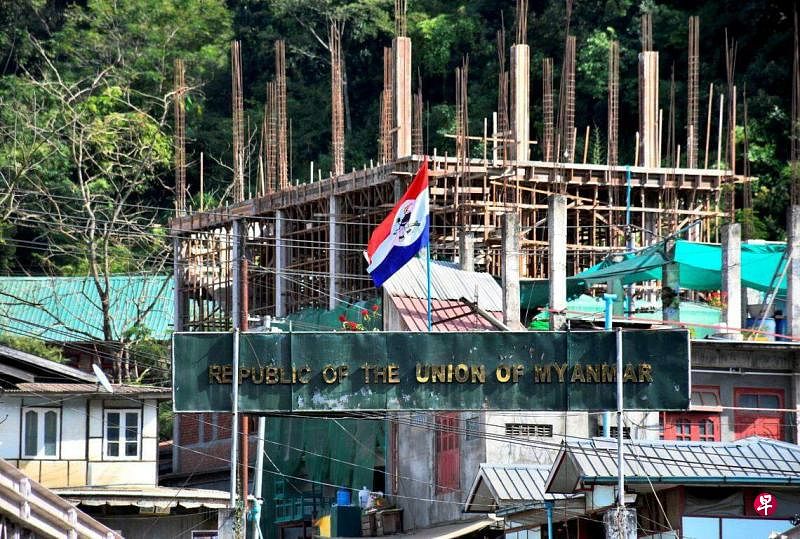 11月14日，印缅边境的缅甸Khawmawi村一处正在建设的建筑旁，悬挂着缅甸武装组织的旗帜。自10月27日以来，武装组织在对缅甸军方的攻势中取得诸多进展。（路透社）