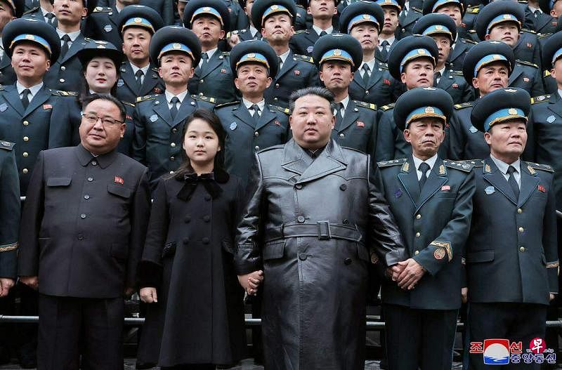 11月23日，朝鲜最高领导人金正恩（前排左三）携女儿金珠爱（前排左二）同国家航空航天技术总局的科学家和技术人员合影留念，庆祝军事侦察卫星发射成功。 （法新社）