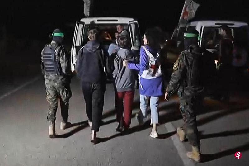 11月27日，哈马斯武装分子将释放的以色列人质交给国际红十字委员会，准备乘车离开。（法新社）