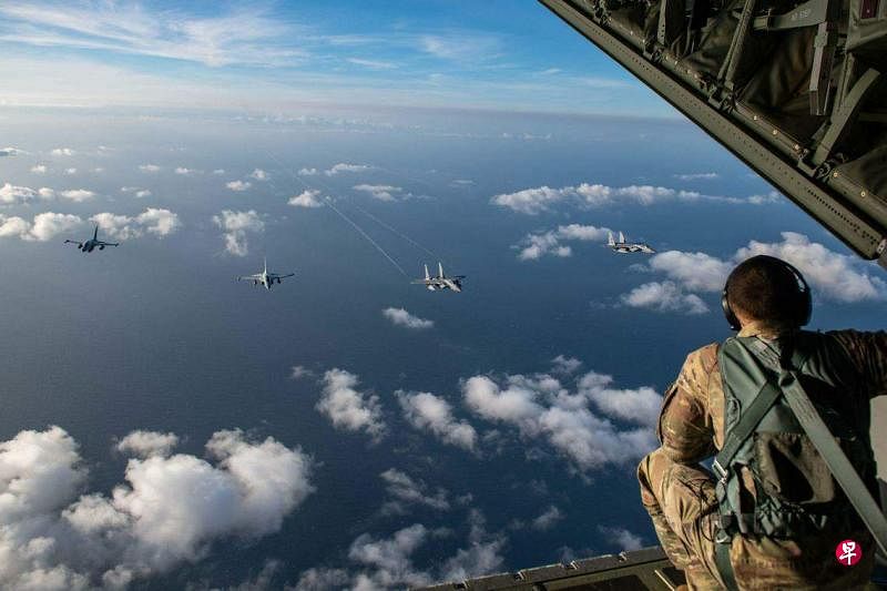 据美国驻马尼拉大使馆所提供的照片，菲美11月21日在南中国海上空举行的空中联合巡逻中，一名美国空军人员在观看两架菲空军FA-50战斗机与两架美国空军F-15C战斗机平行齐飞。（法新社）
