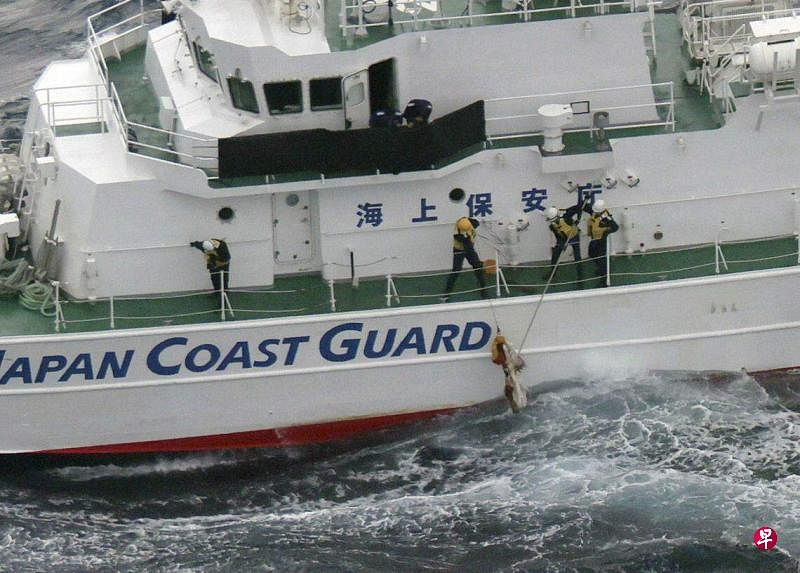11月30日，日本海上保安厅成员在屋久岛附近海域打捞战机残骸。（路透社）