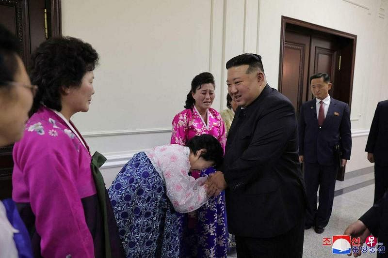 12月4日，朝鲜领导人金正恩（右）在平壤会见第五届全国母亲大会的与会者。这是朝鲜时隔11年再次举行全国母亲大会。（法新社）