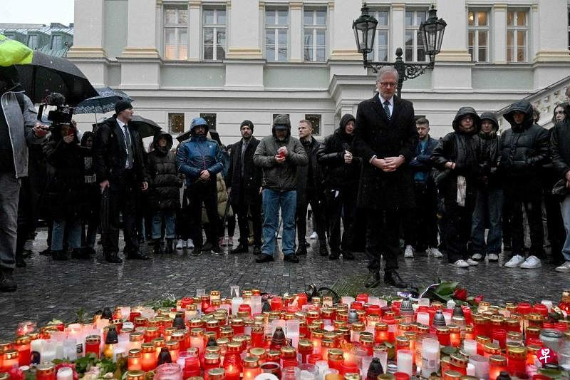 12月22日，捷克总理菲亚拉来到布拉格查理大学点燃蜡烛。查理大学星期四发生枪击案，造成14人遇难。（法新社）