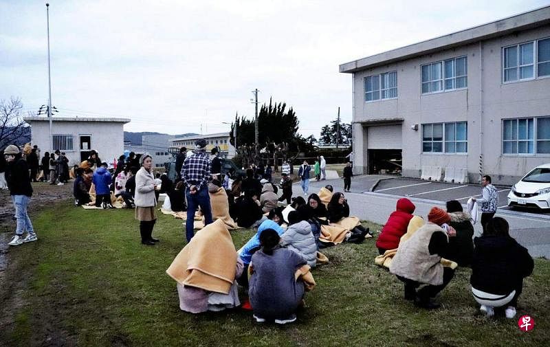 1月1日下午，日本石川县能登半岛（Noto Peninsula）发生7.6级强震，人们紧急撤离建筑物后蹲坐在户外。（法新社）
